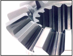 Photo 6; Shows a close-up of the teeth of the bevel gear as shown in Photo 1. The gear was processed using the described chemically accelerated vibratory finishing technique to generate the Isotropic Superfinish. The resultant surface has an is Ra of 1.5 μinches. Note when compared to Photo 1, that all grind line asperities have been removed.